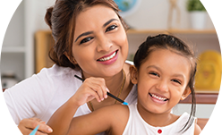 image for smiling woman and girl coloring at table